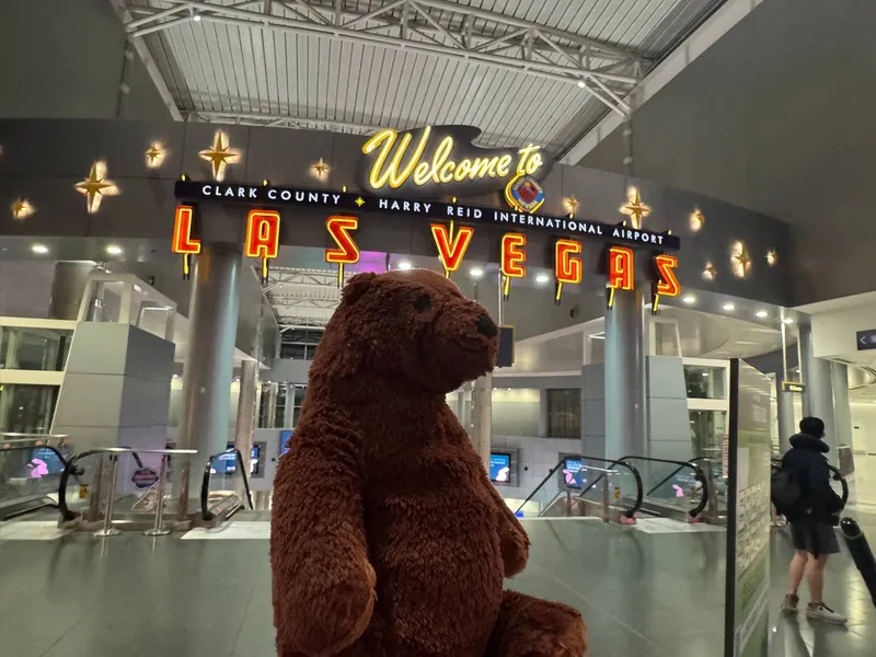 拉斯維加斯機場的 Welcome to Las Vegas 招牌前，一隻棕色絨毛熊